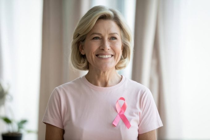 Older woman in pink t-shirt showing support for Breast Cancer Awareness